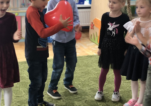 Dzieci przekazują sobie _balonowe serduszko